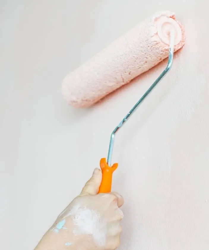 man painting an inside wall